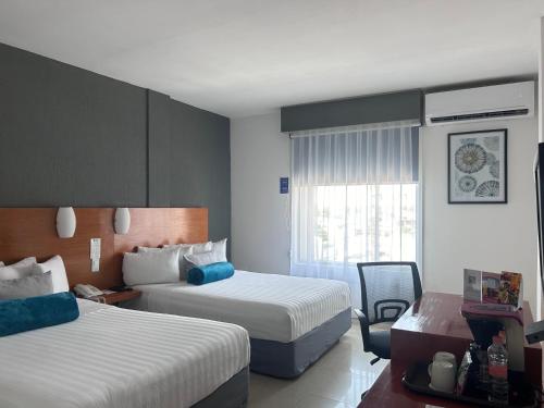 米纳蒂特兰Best Western Minatitlan的酒店客房设有两张床和窗户。