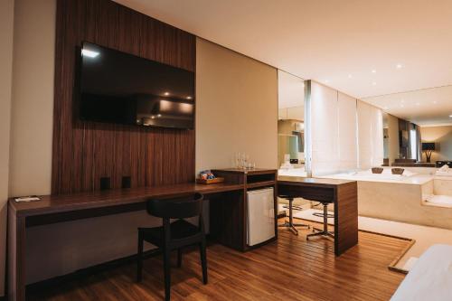 卡夸尔Catuai Hotel的客房设有书桌和带水槽的厨房