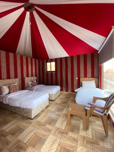 DisahWadi rum Gory camp的红色天花板的客房内的两张床