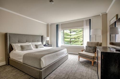 柯克兰伍马克目的地酒店的卧室配有床、椅子和窗户。