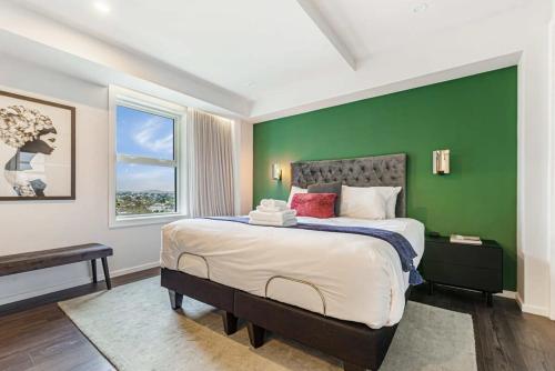 奥克兰Awesome Apartment w Parking的一间卧室设有一张大床和绿色的墙壁