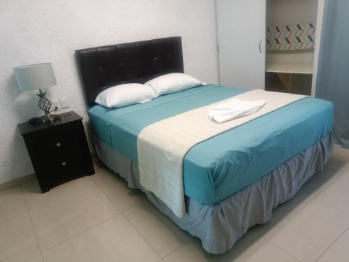 科苏梅尔Hotel Dos Mundos, Isla Cozumel的一间卧室配有一张带蓝色床单和白色枕头的床。