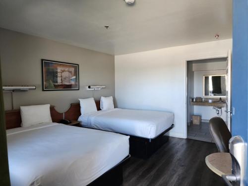 巴斯托Motel 6 Barstow, CA I15 and Lenwood Road的酒店客房设有两张床和一张桌子。