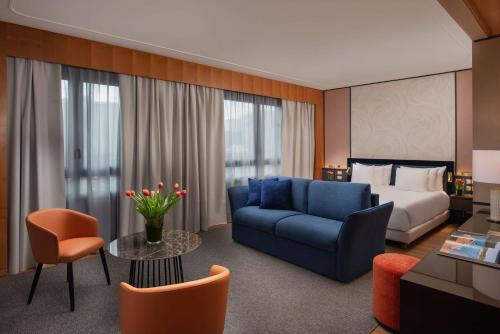 热那亚热那亚码头NH典藏酒店的酒店客房,配有床和蓝色的沙发