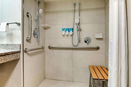 马里恩Drury Inn & Suites Marion的浴室设有带长凳的步入式淋浴间