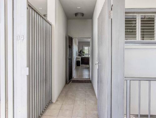 金斯克里福Drift North Beachfront Apartments - Private Apartments的走廊设有白色墙壁和瓷砖地板