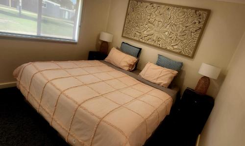 莱克斯恩特伦斯回音海滩观光假日公园的一间卧室配有一张大床和两个枕头