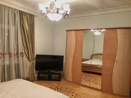 巴库Luxury villa 8 bedrooms的一间带镜子、一张床和电视的卧室