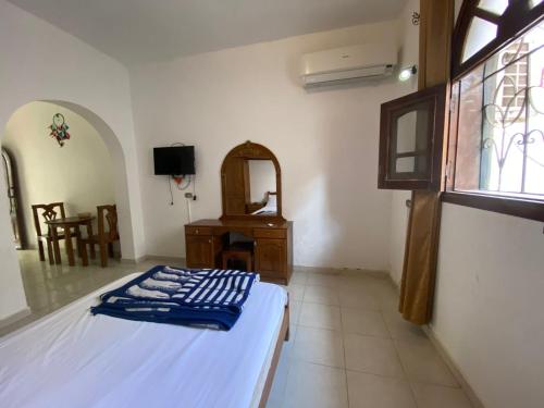 达哈布Red oasis的一间卧室配有一张床、一张书桌和一个窗户。