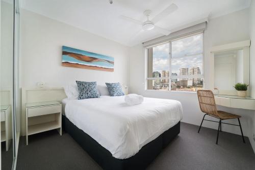 悉尼Harbourside #49的一间卧室配有一张床、一张书桌和一个窗户。