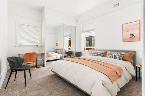 悉尼Spacious Boutique Apartment in Beautiful Art Deco Block的一间卧室配有两张床和一张桌子及椅子