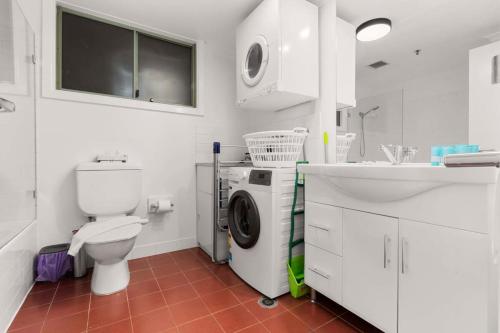 悉尼1 BR Apartment In the Heart of Darling Harbour的一间带卫生间和洗衣机的浴室。