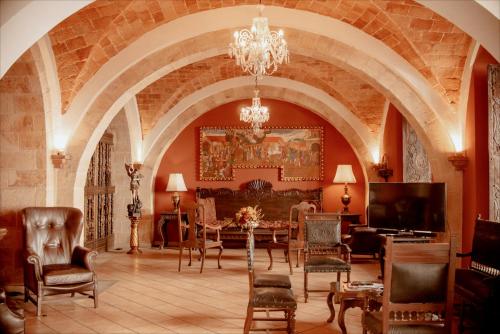 苏克雷圣玛丽亚皇家酒店的客厅配有桌椅和吊灯。