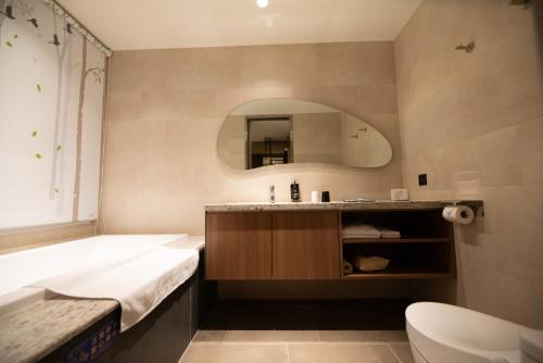 永康晶盈亲旅大酒店 的带浴缸、水槽和浴缸的浴室