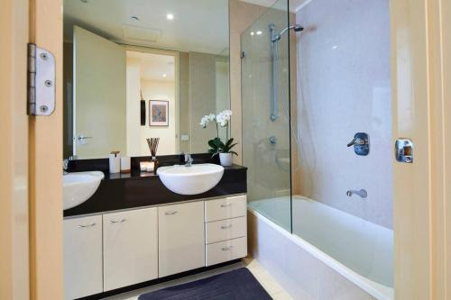 墨尔本Penthouse Apartment in Melb CBD Perfect Location的一间带两个盥洗盆和淋浴的浴室