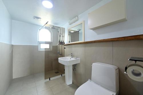 西归浦市Sweet Stay Pension的浴室配有白色卫生间和盥洗盆。