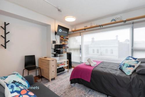 悉尼Studio Gem With Rooftop Space Prime Location的一间卧室设有一张床和一个大窗户