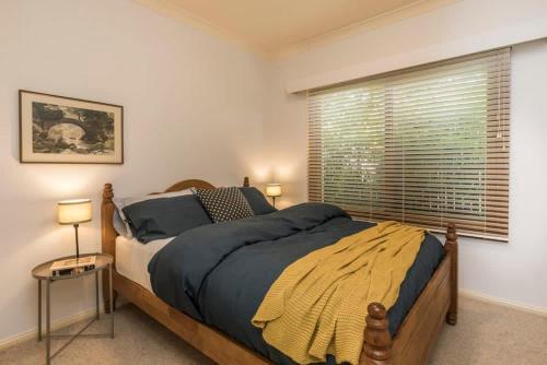 堪培拉3 Bdrm 2 Bthrm House Close to Canberra CBD & ANU的一间卧室设有一张大床和一个窗户。