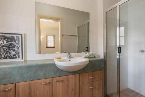 堪培拉3 Bdrm 2 Bthrm House Close to Canberra CBD & ANU的一间带水槽和玻璃淋浴的浴室