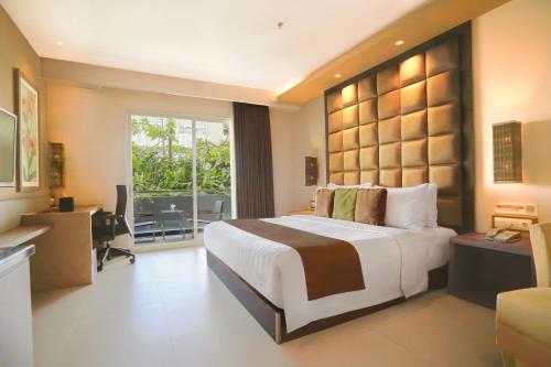 日惹日惹伊斯特帕克酒店的一间卧室配有一张大床、一张桌子和一个窗户。