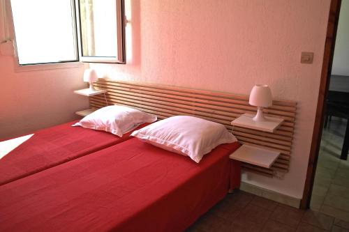 卡尔维Residence Thalassa的一间卧室配有红色的床、两个枕头和窗户