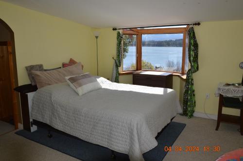 考特尼Estuary House Reflexology B&B的卧室配有白色的床和窗户。