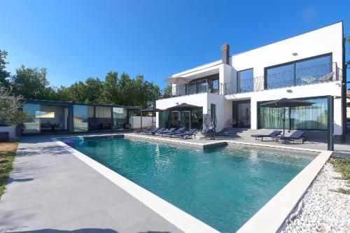 罗波里卡Ferienhaus mit Privatpool für 10 Personen ca 300 qm in Loborika, Istrien Südküste von Istrien的房屋前有游泳池的房子