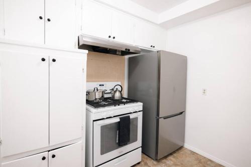 霍桑ModernHaven -SoFi, Forum, Intuit的厨房配有白色橱柜和不锈钢冰箱