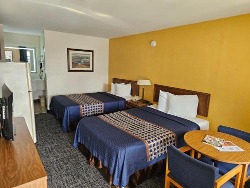 列克星敦兰草艾斯坦德斯戴酒店的酒店客房设有两张床和一张桌子。