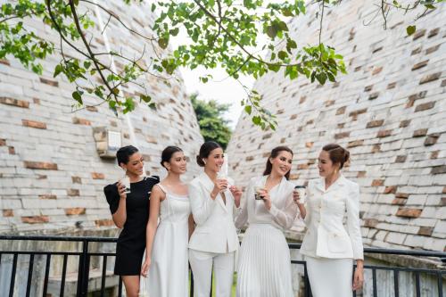 邦美蜀The Coffee City - Healing & Retreats的一群身着白色服装的妇女站在一座建筑物前