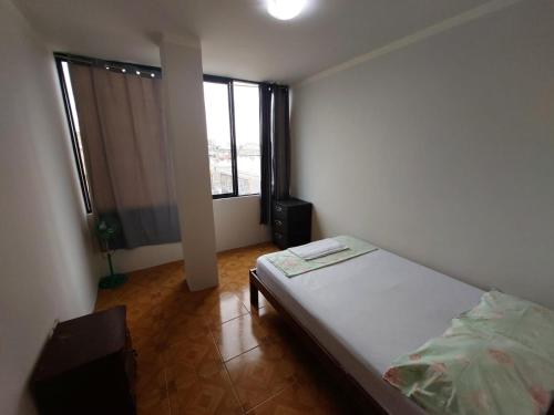 马查拉Departamentos de la Costa的一间卧室设有一张床和一个大窗户