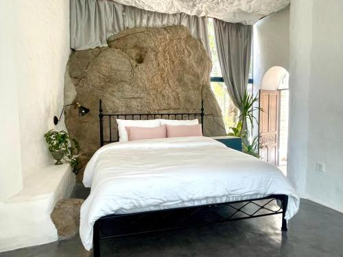 Thôn Bình HưngRosarii Pacis Villa - Venuestay的一间卧室配有一张带大岩石的床