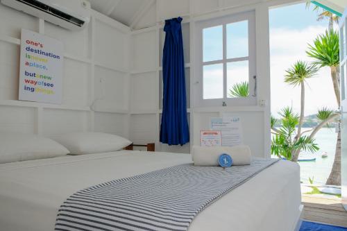 蓝梦岛Le Pirate Beach Club Nusa Ceningan - Adults Only的白色卧室设有一张大床和窗户