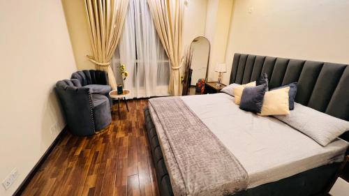 伊斯兰堡Executive One Bedroom Apartment Opposite Centaurus Mall Islamabad的一间卧室配有一张大床和一把椅子