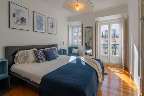 里斯本Superb Apartments Overlooking Graça in Lisbon的一间卧室配有一张带蓝色毯子的床