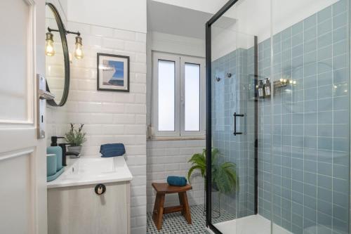 里斯本Superb Apartments Overlooking Graça in Lisbon的浴室设有水槽和蓝色瓷砖淋浴。