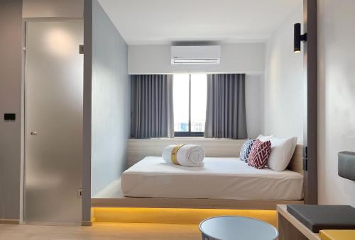 合艾Hatyai Midtown Hotel的一间卧室设有一张床和一个窗口