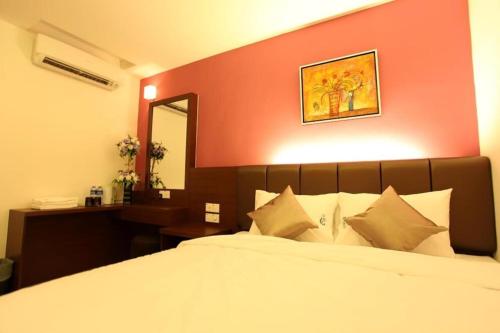 马六甲AVARIA SIGNATURE的一间卧室设有一张红色墙壁的大床