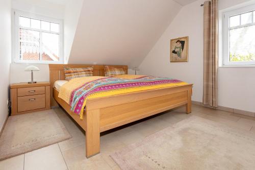 博尔库姆Ferienhaus Inselliebe的一间卧室设有木床和2个窗户。