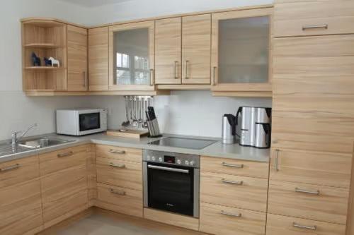 博尔库姆Ferienhaus Inselliebe的厨房配有木制橱柜和炉灶烤箱。