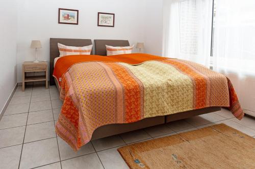 博尔库姆Ferienhaus Inselkate的一间卧室配有一张带橙色毯子的床