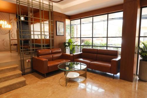 科泽科德Hotel Blue Bell的客厅配有沙发和桌子