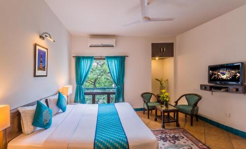 新德里Home@F37 Kailash Colony Metro的一间酒店客房,配有一张床和一台电视