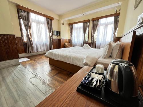 甘托克Yesheyzz的一间酒店客房,配有一张床铺和一张桌子上的电话
