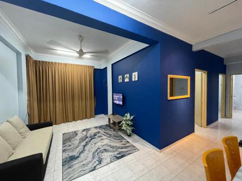 艾尔克如Serene Bukit Beruang Cottage 4 ROOMS FULL AIRCOND & NETFLIX by EZYROOM MELAKA的客厅拥有蓝色的墙壁和沙发