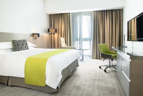 马斯喀特Novotel Muscat Airport的酒店客房,配有床和电视