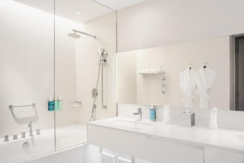 马斯喀特Novotel Muscat Airport的白色的浴室设有水槽和淋浴。