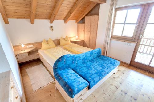 阿皮亚诺苏拉斯特拉达拉温德尔霍夫公寓的一间卧室,在房间内配有一张蓝色的大沙发