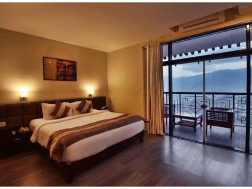 甘托克Tara valley view的一间卧室设有一张大床和一个大窗户