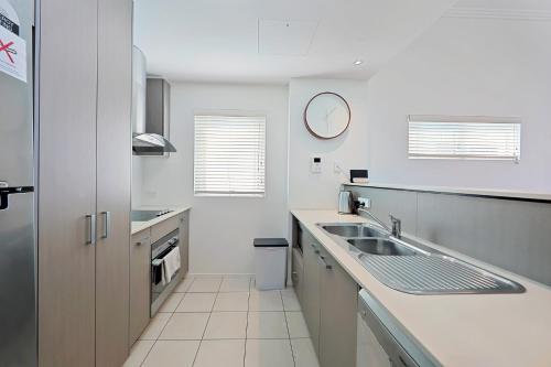 巴加拉Dwell @ 25, Oceanfront Apartment的白色的厨房设有水槽和台面